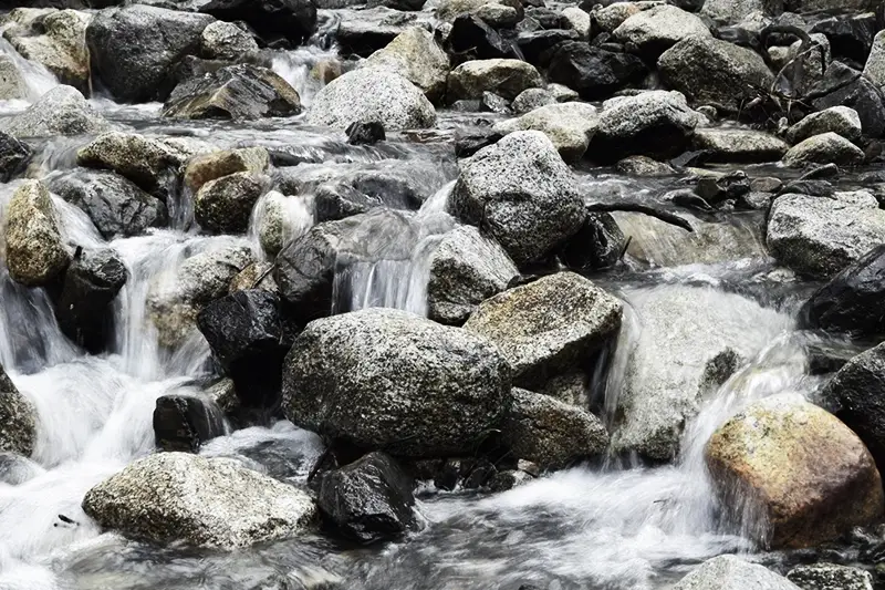 Ein Fluss fließt zwischen Felsen durch die Natur.